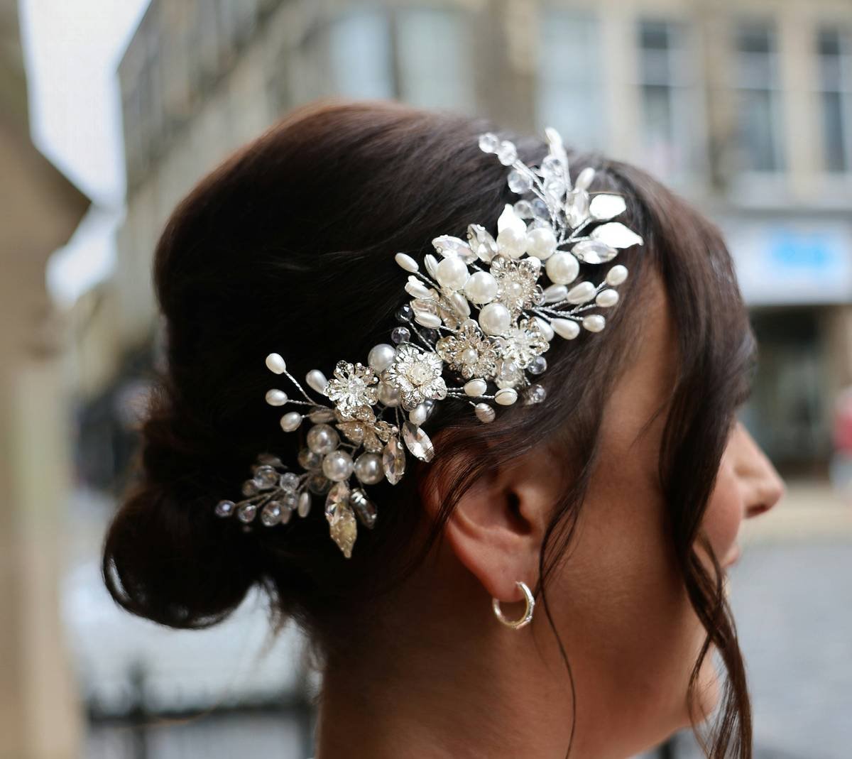 Woman wearing elegant headgear with soft waves and natural makeup