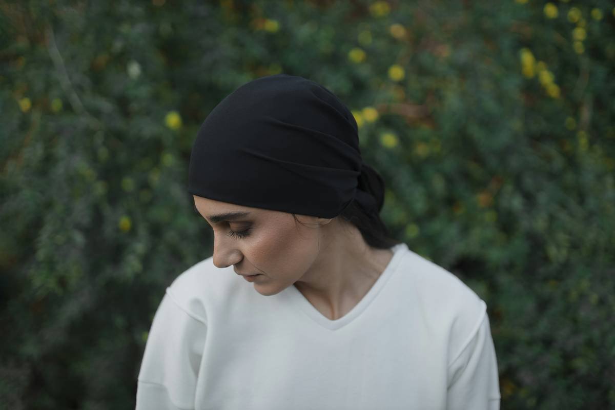 woman applying genuine silk hair wrap for overnight protection