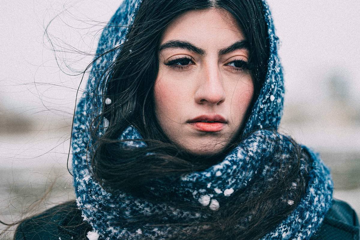Woman adjusting a stylish head scarf for curly hair protection